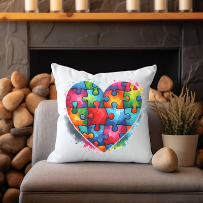 Colorful heart-shaped jigsaw puzzle design on a white throw pillow, placed on a cozy chair near a fireplace with stone decorations.