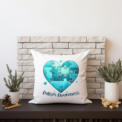 Autism Awareness pillow with blue puzzle heart design on mantel with plants