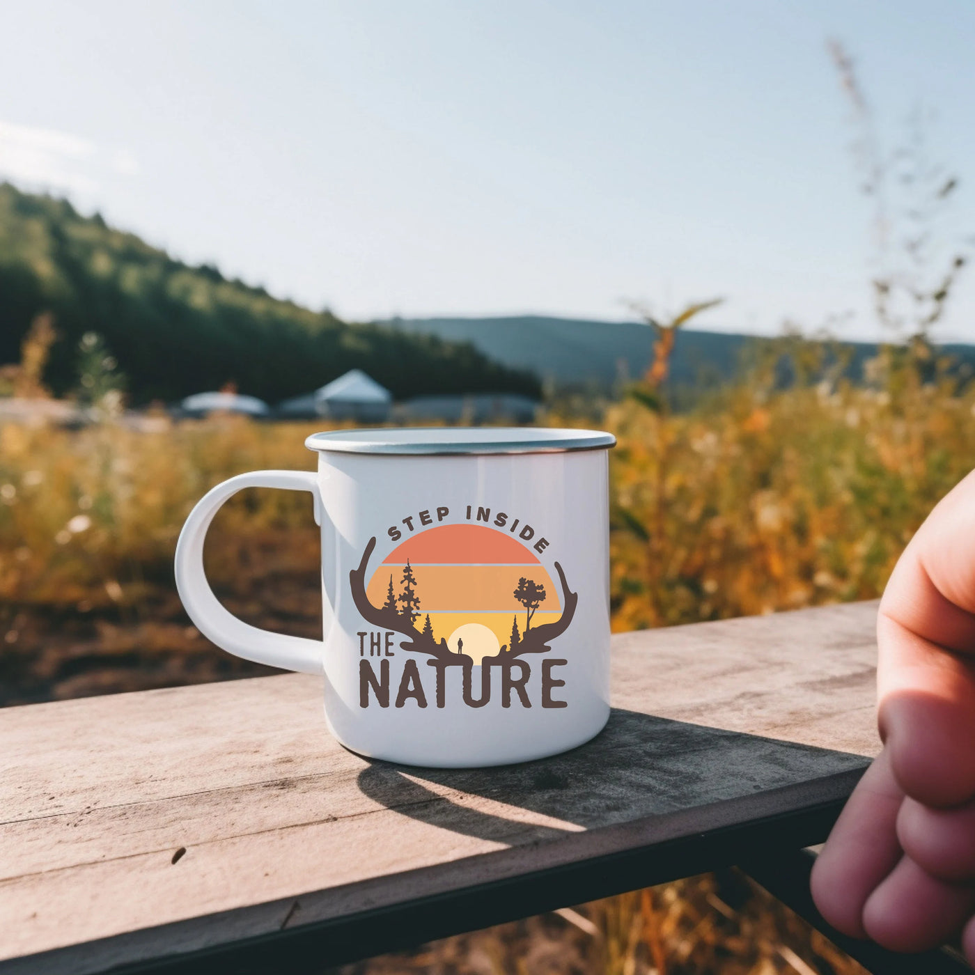 a person holding a coffee mug on a wooden table