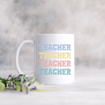 a white coffee mug with the words teacher on it