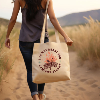 a woman walking down a dirt road carrying a bag