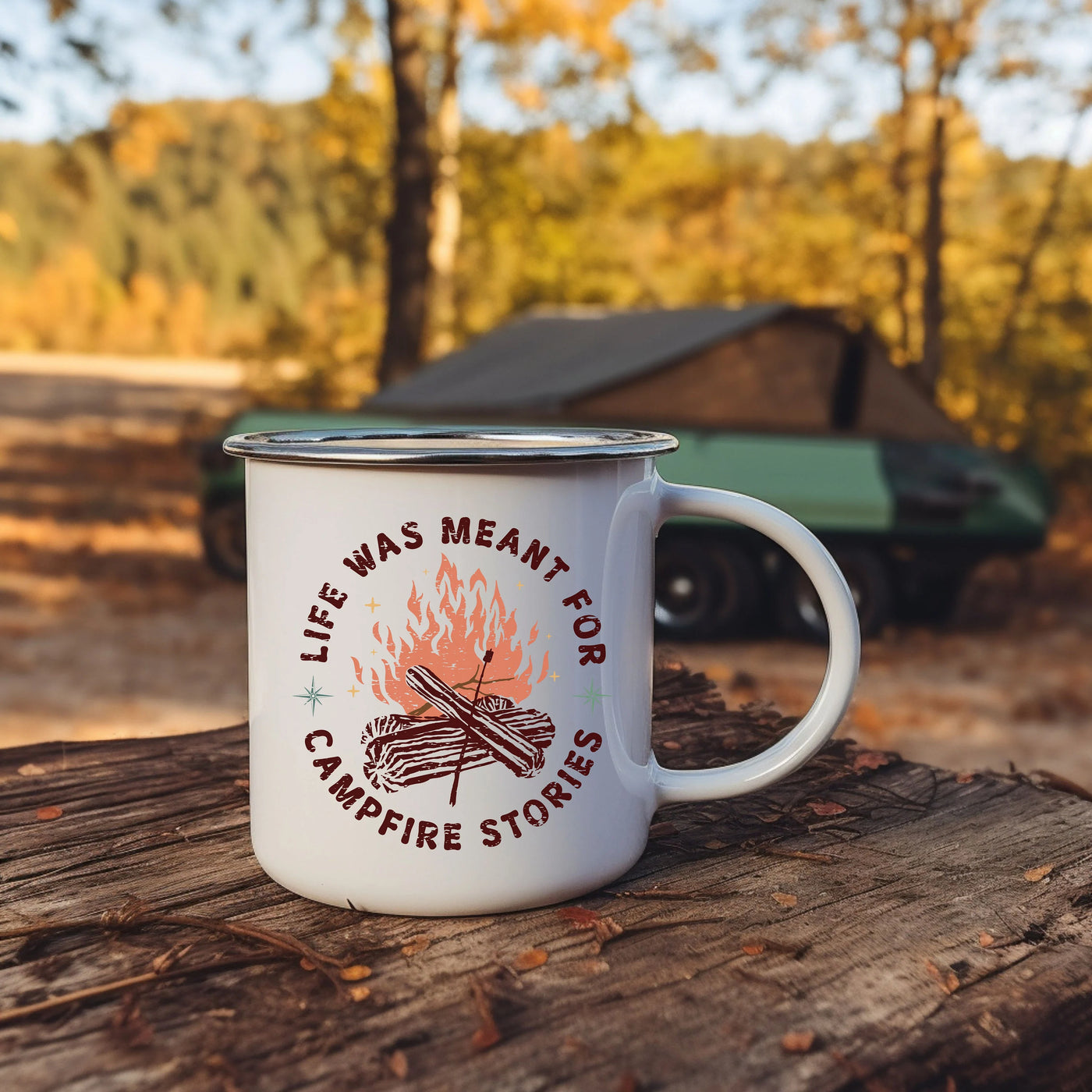 a campfire mug sitting on top of a log