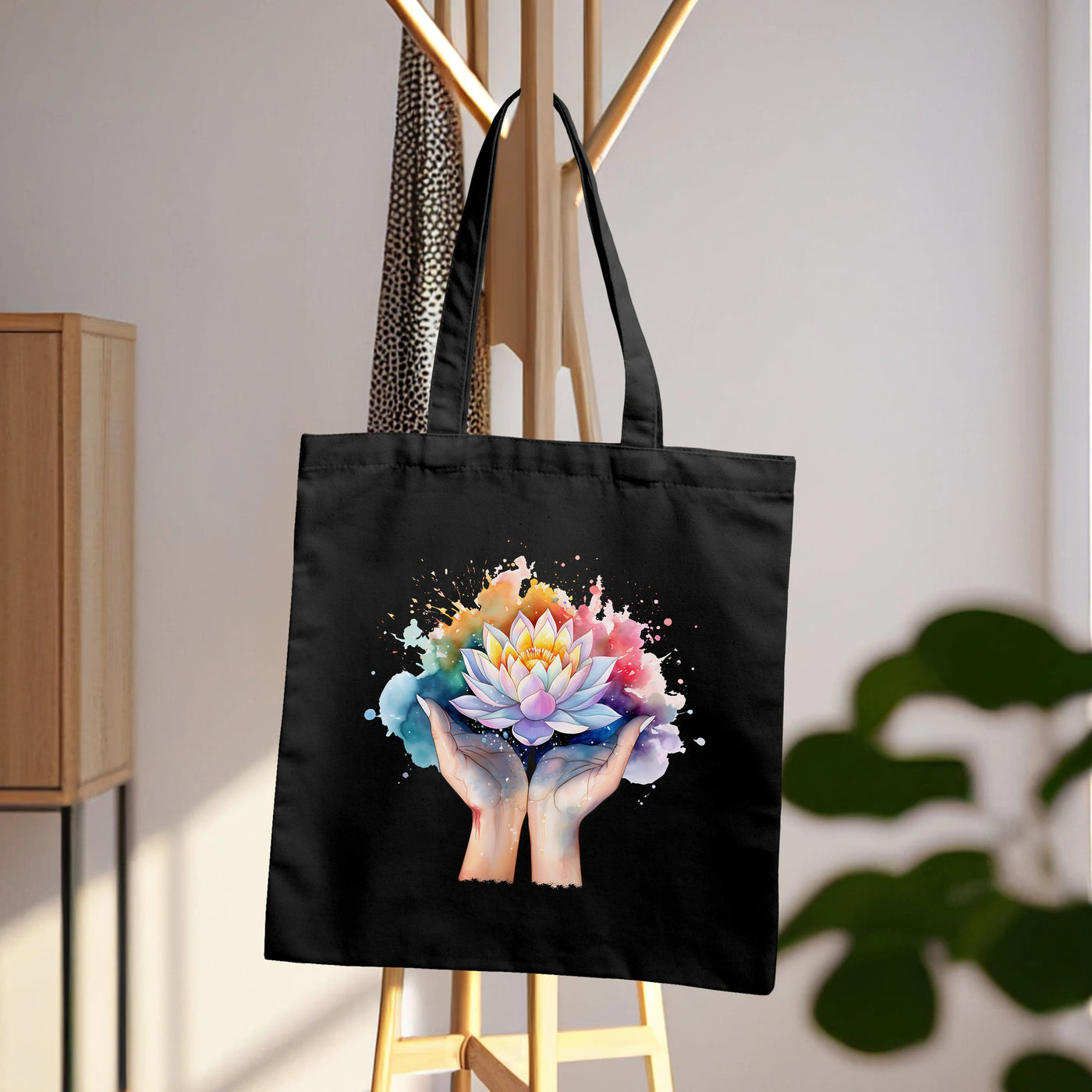 a black tote bag with a picture of two hands holding a flower