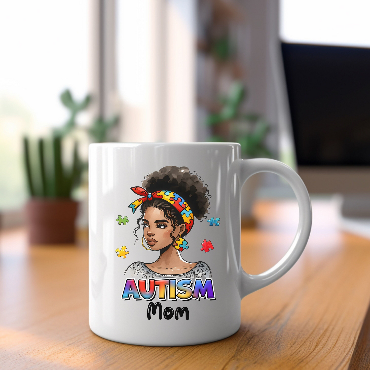 White coffee mug with "Autism Mom" design depicting a woman with a colorful headband and puzzle pieces, on a wooden desk background