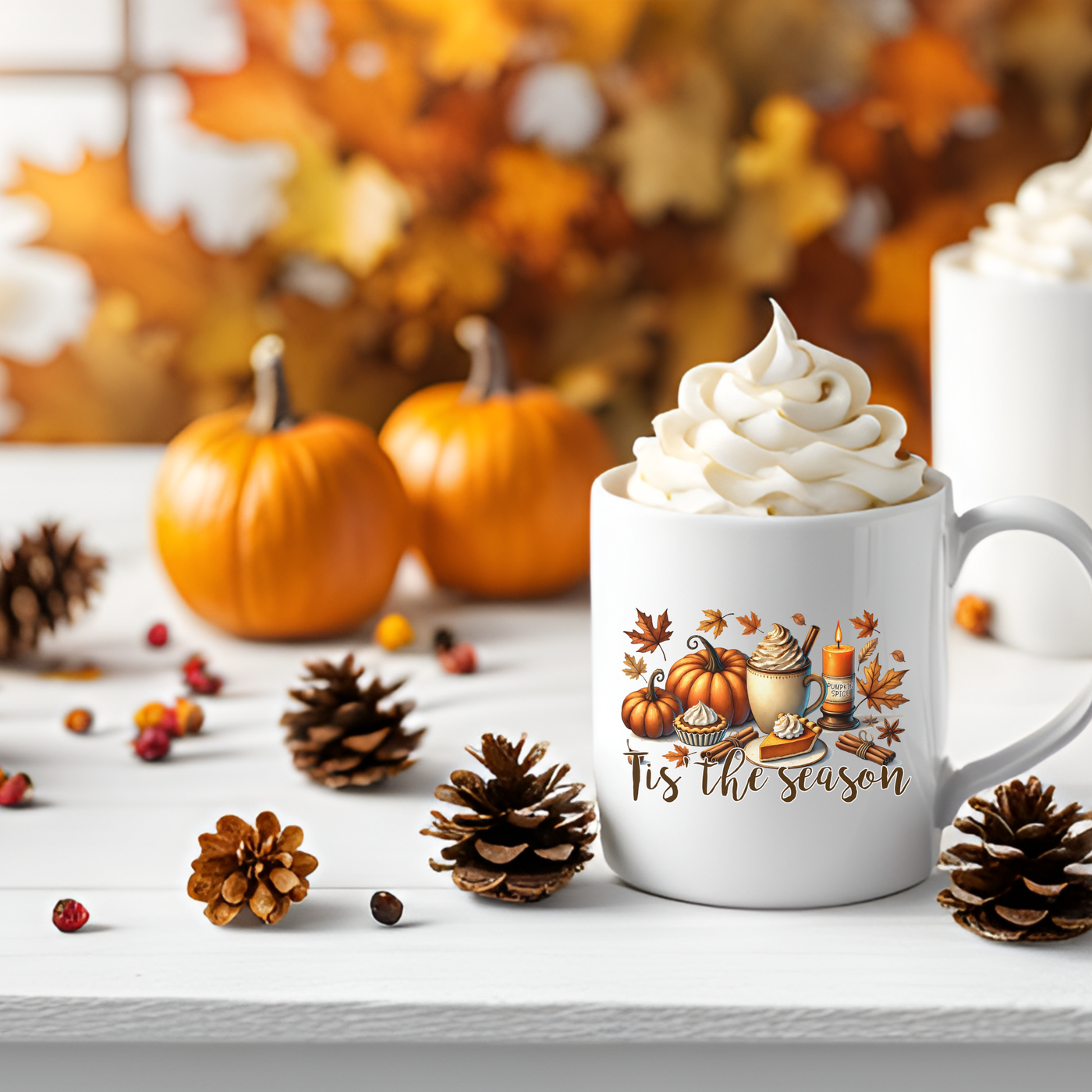 a cup of coffee with whipped cream and pumpkins around it