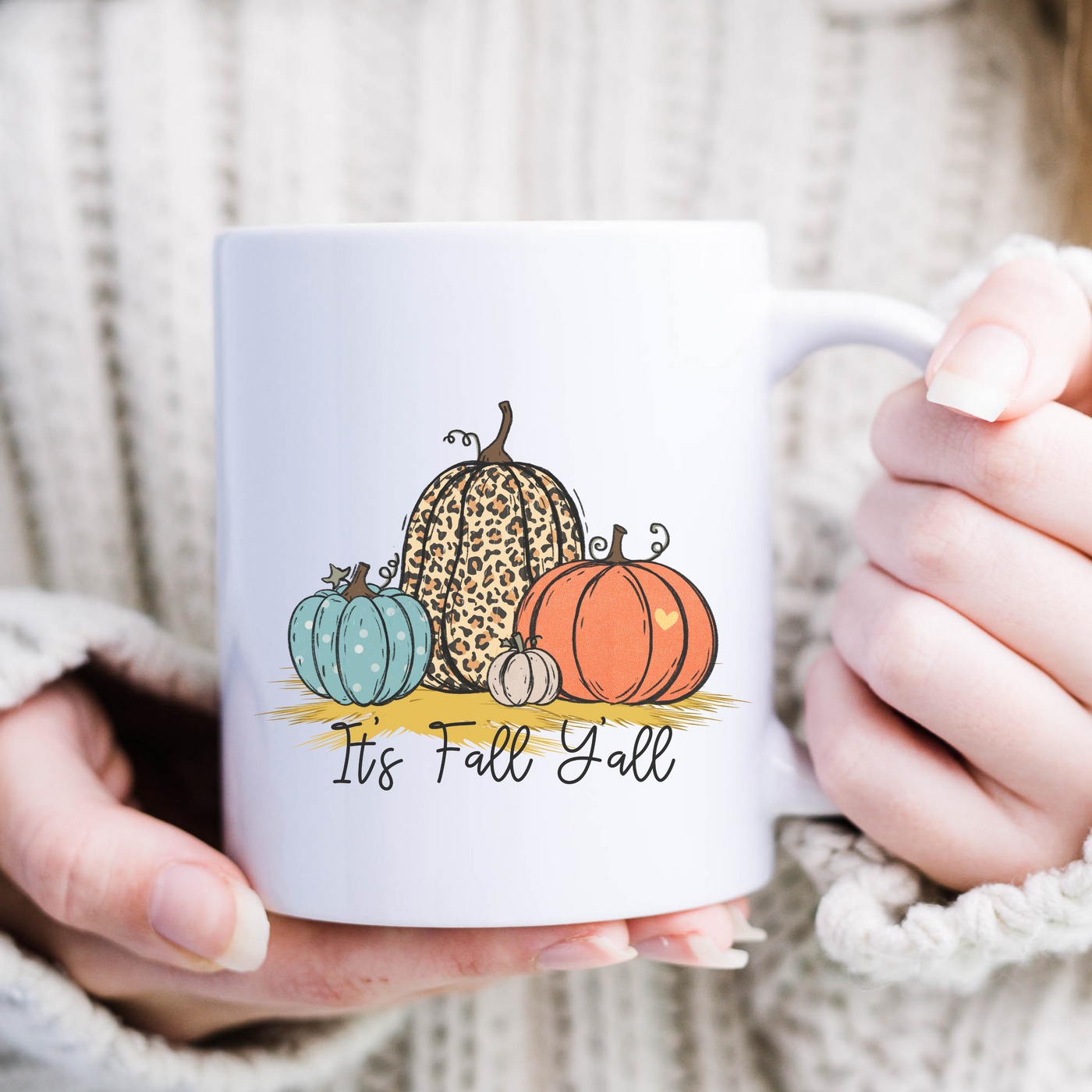 a woman holding a coffee mug with a pumpkin design on it