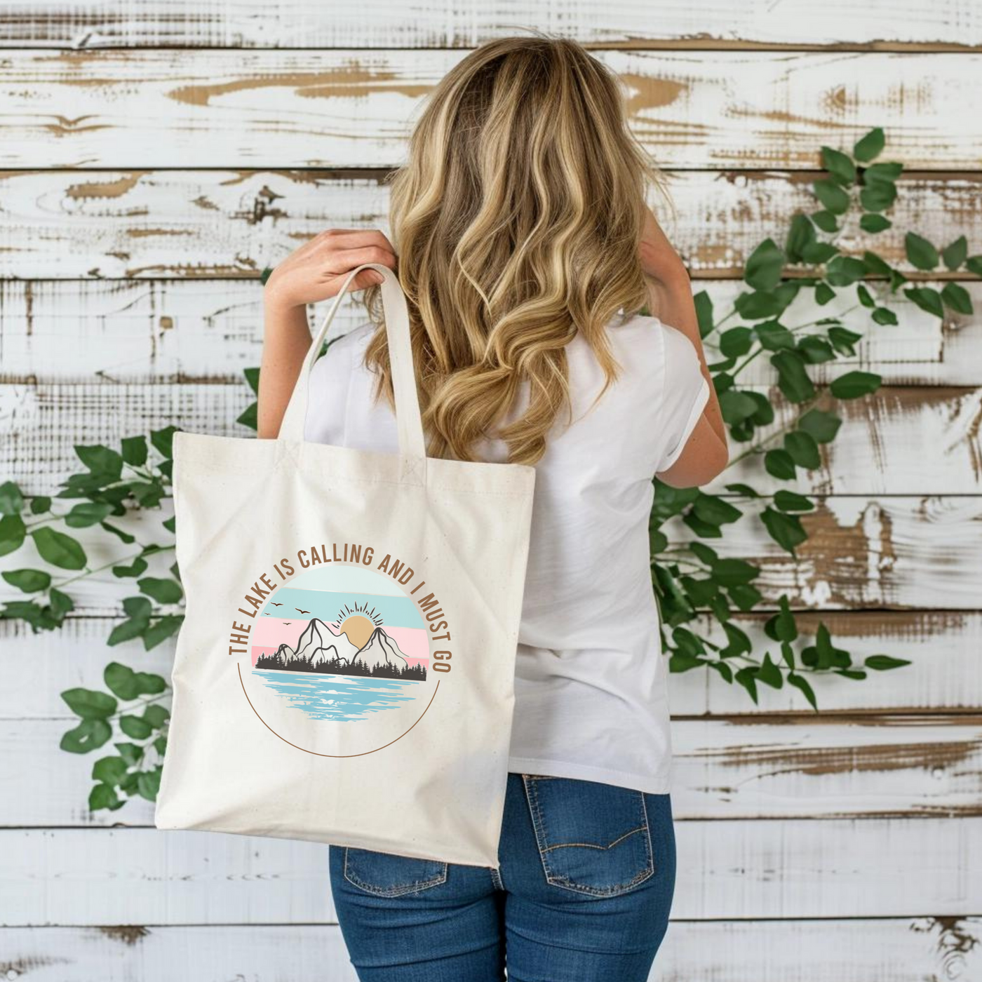 a woman carrying a white bag with a mountain scene on it