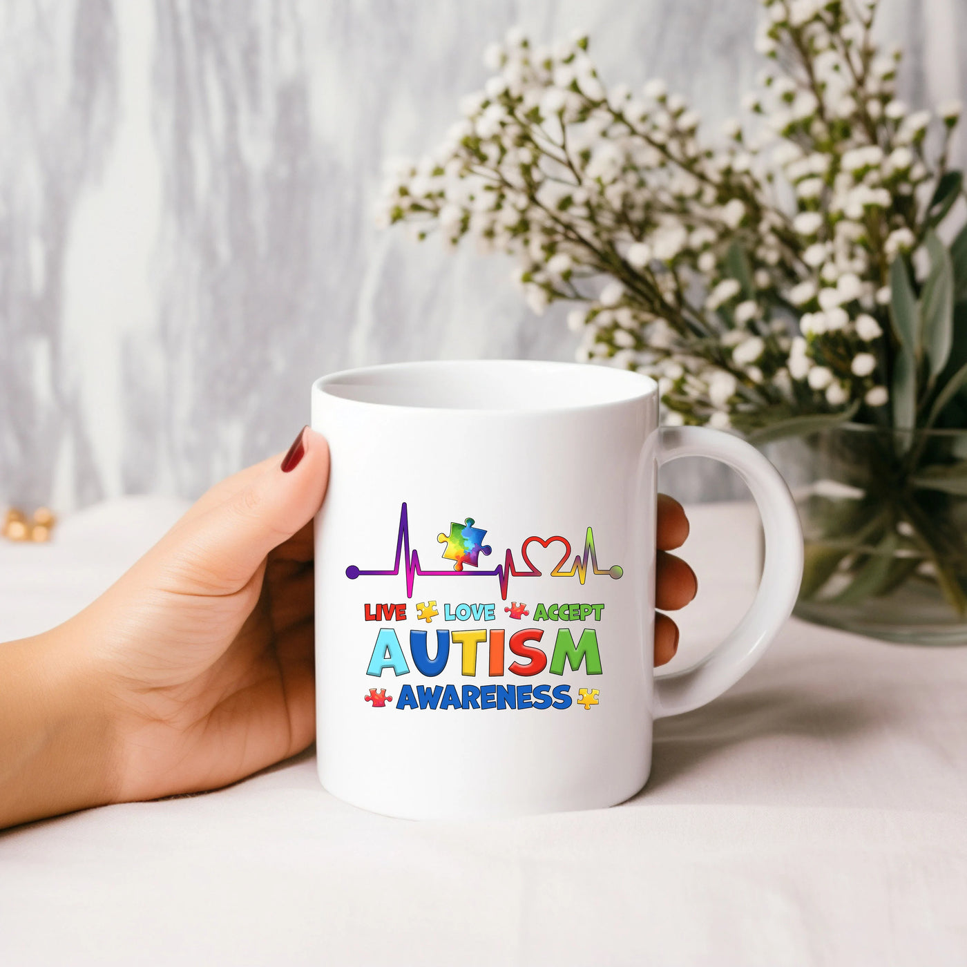 a person holding a coffee mug with autism on it