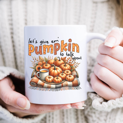 a woman holding a coffee mug with pumpkins on it