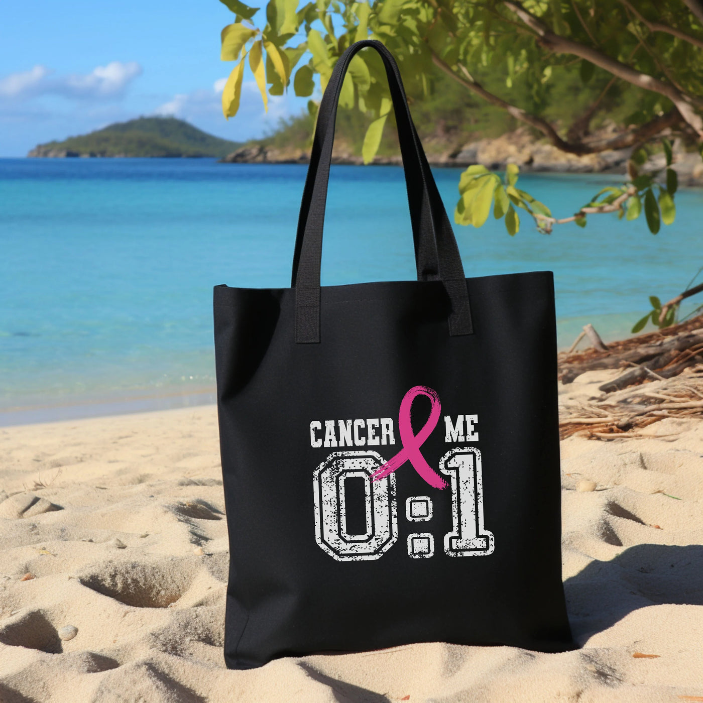 a black bag with a pink ribbon on the beach