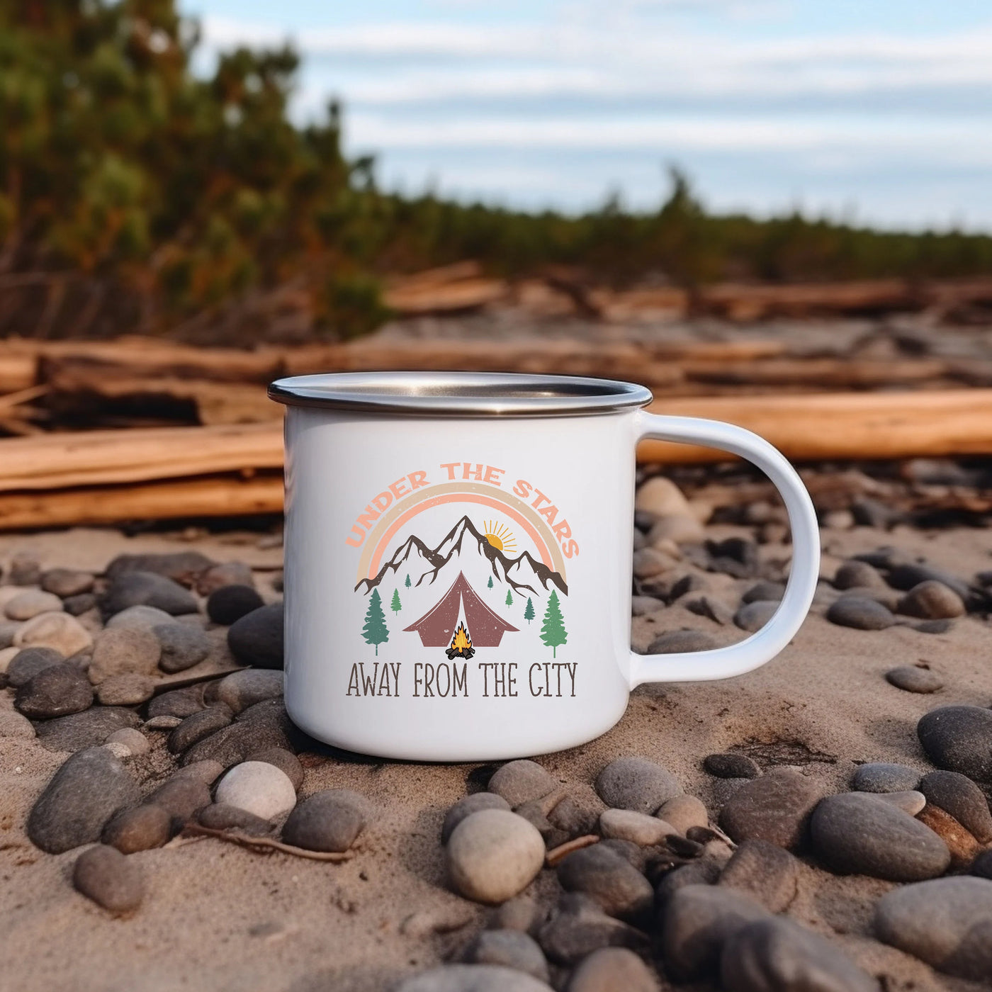 a white camp mug sitting on top of a rocky beach