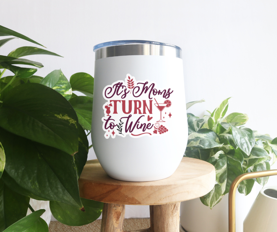 a white tumbler sitting on top of a wooden stool next to a potted