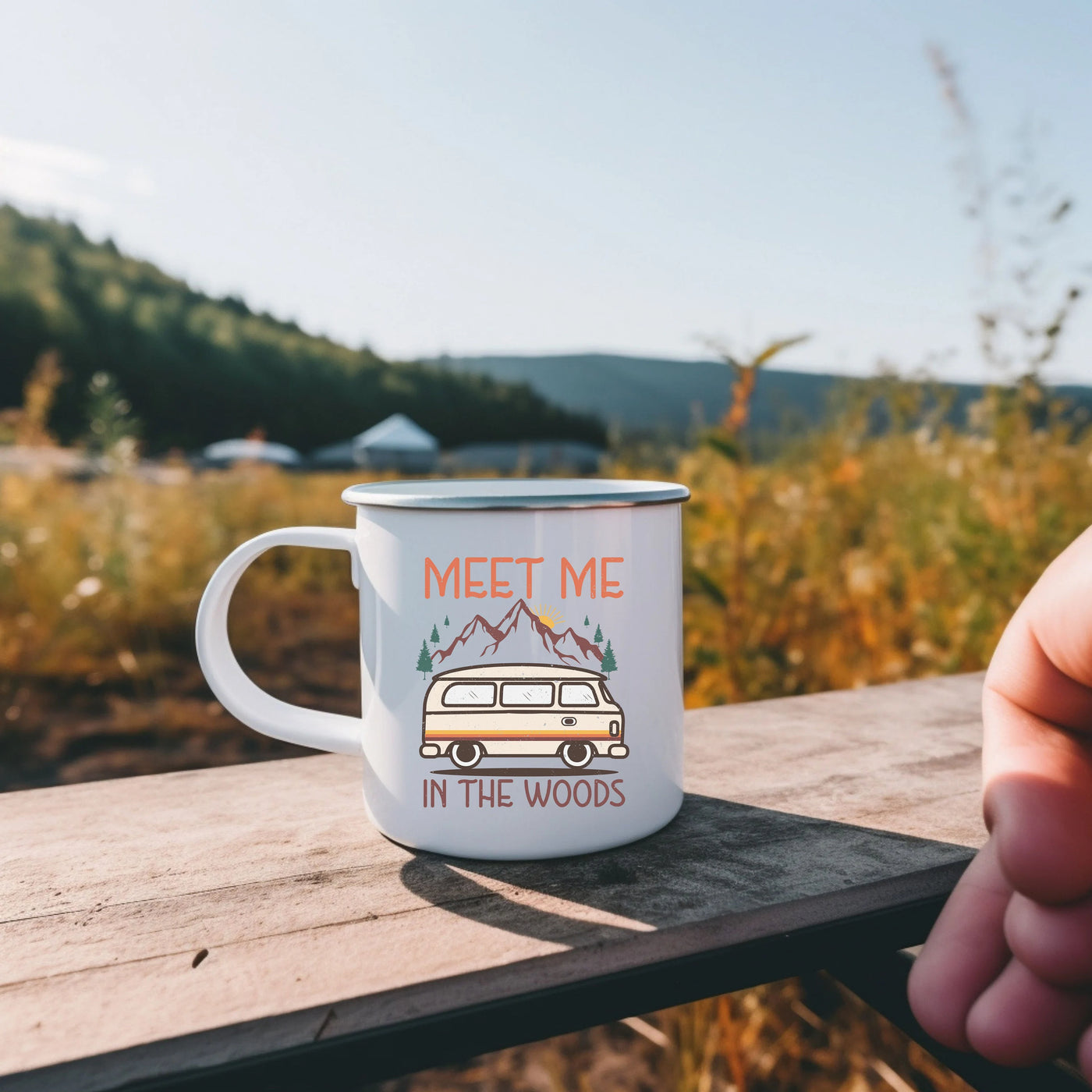 a person holding a coffee mug with a camper on it