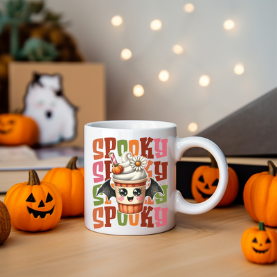 a white coffee mug with a spooky spooky cupcake on it