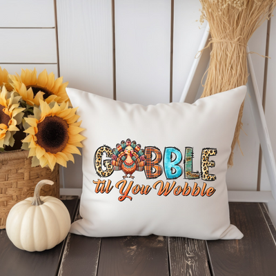 a white pillow with the word gobble on it next to a sunflower