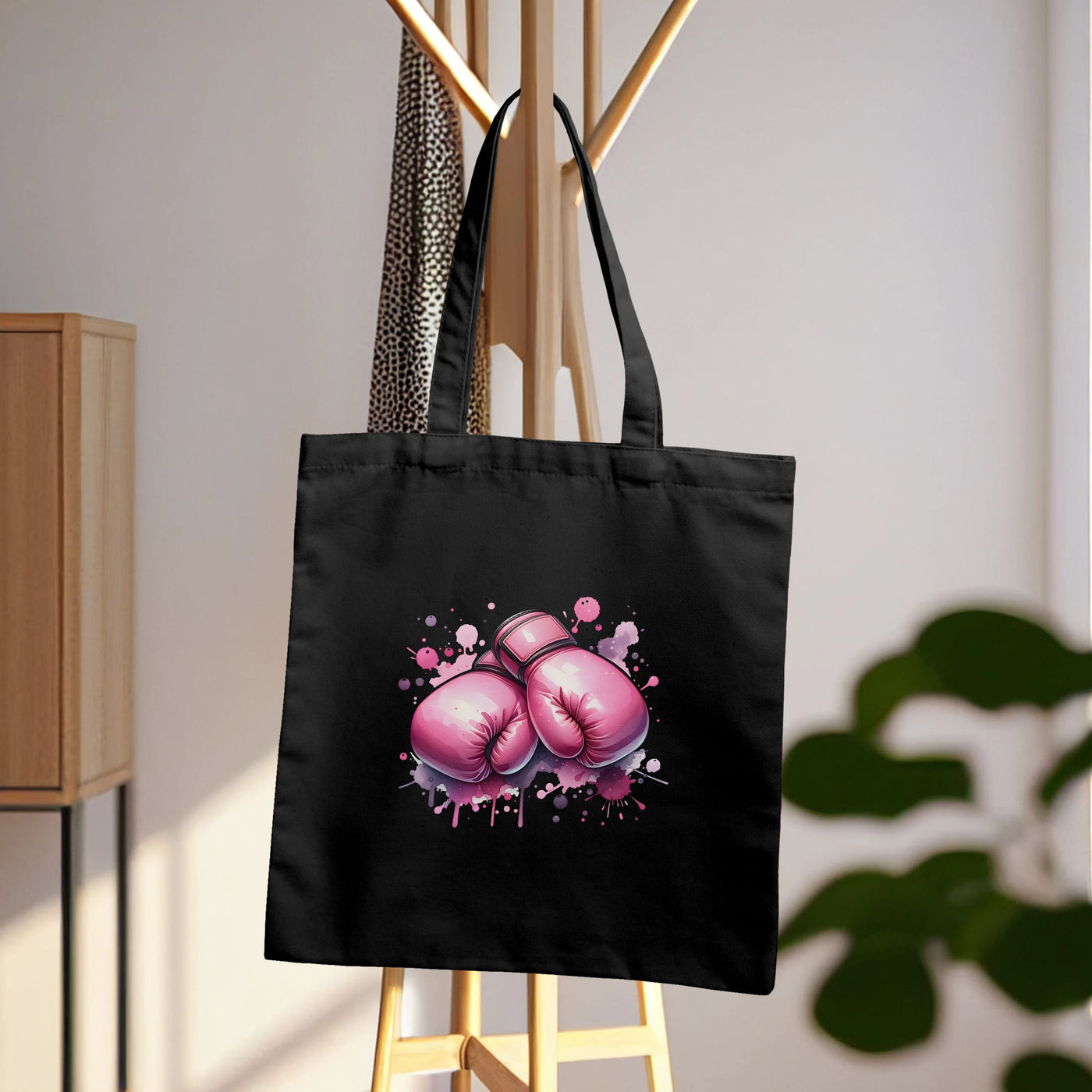 a black tote bag with pink boxing gloves on it