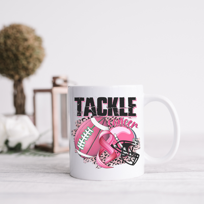 a coffee mug with a football helmet and a pink ribbon