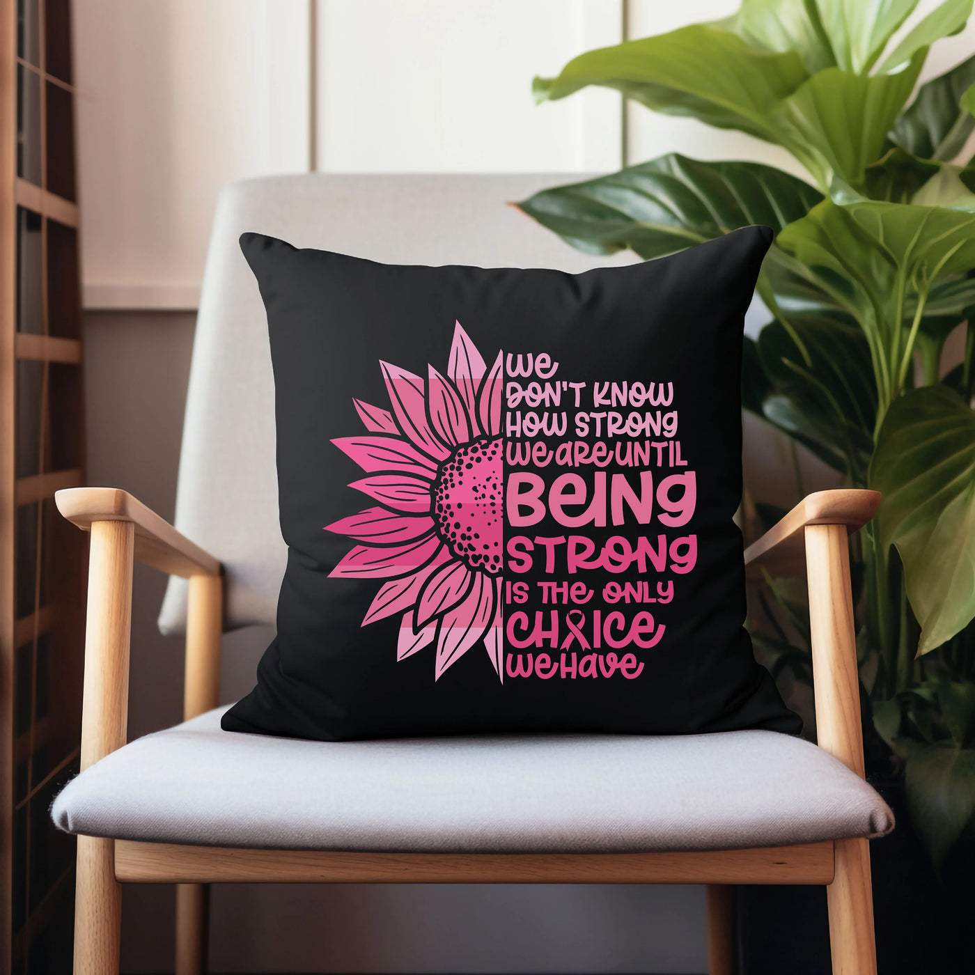 a black pillow with a pink sunflower on it