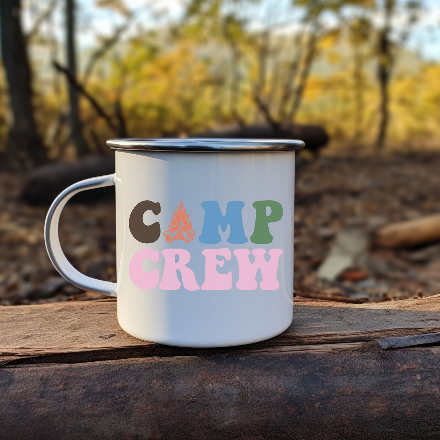 a camp crew coffee mug sitting on a log