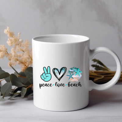 a white coffee mug with peace love beach written on it