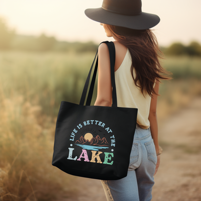 a woman carrying a black tote bag that says life is better at the lake