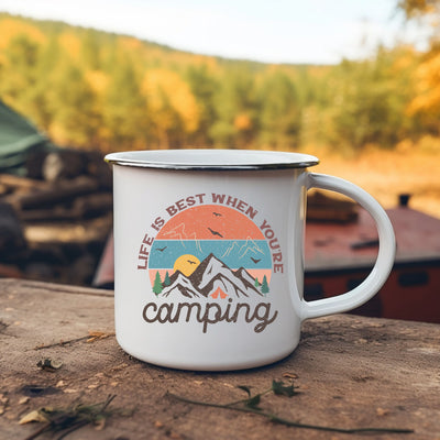 a white camp mug sitting on top of a wooden table