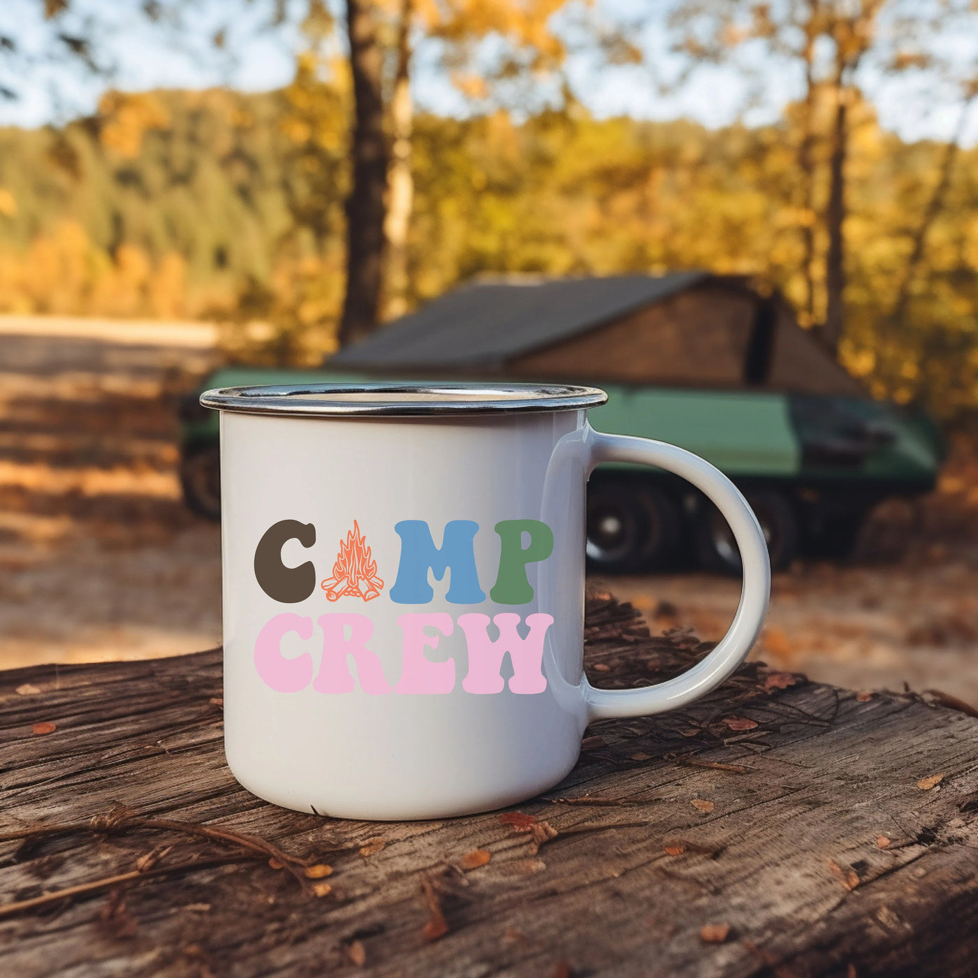 a camp crew coffee mug sitting on a log