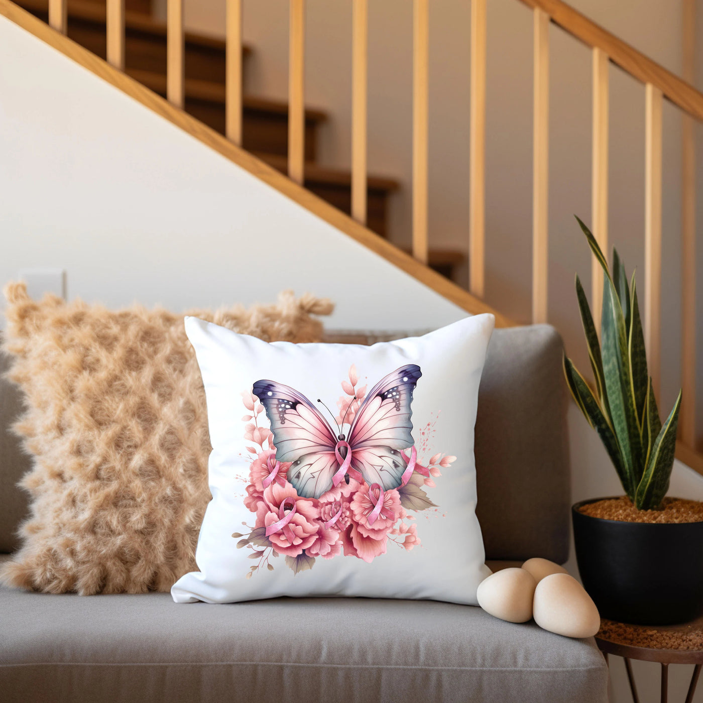 a white pillow with a pink flower and a butterfly on it