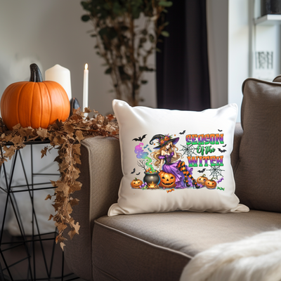 a halloween pillow sitting on a couch next to a pumpkin