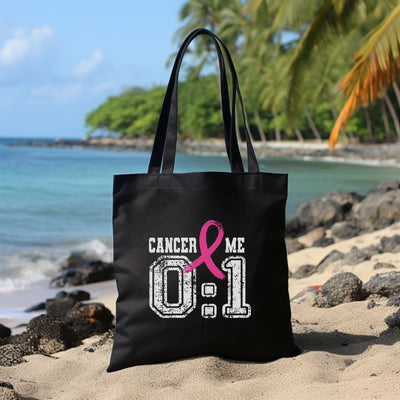 a black tote bag with a pink ribbon on it