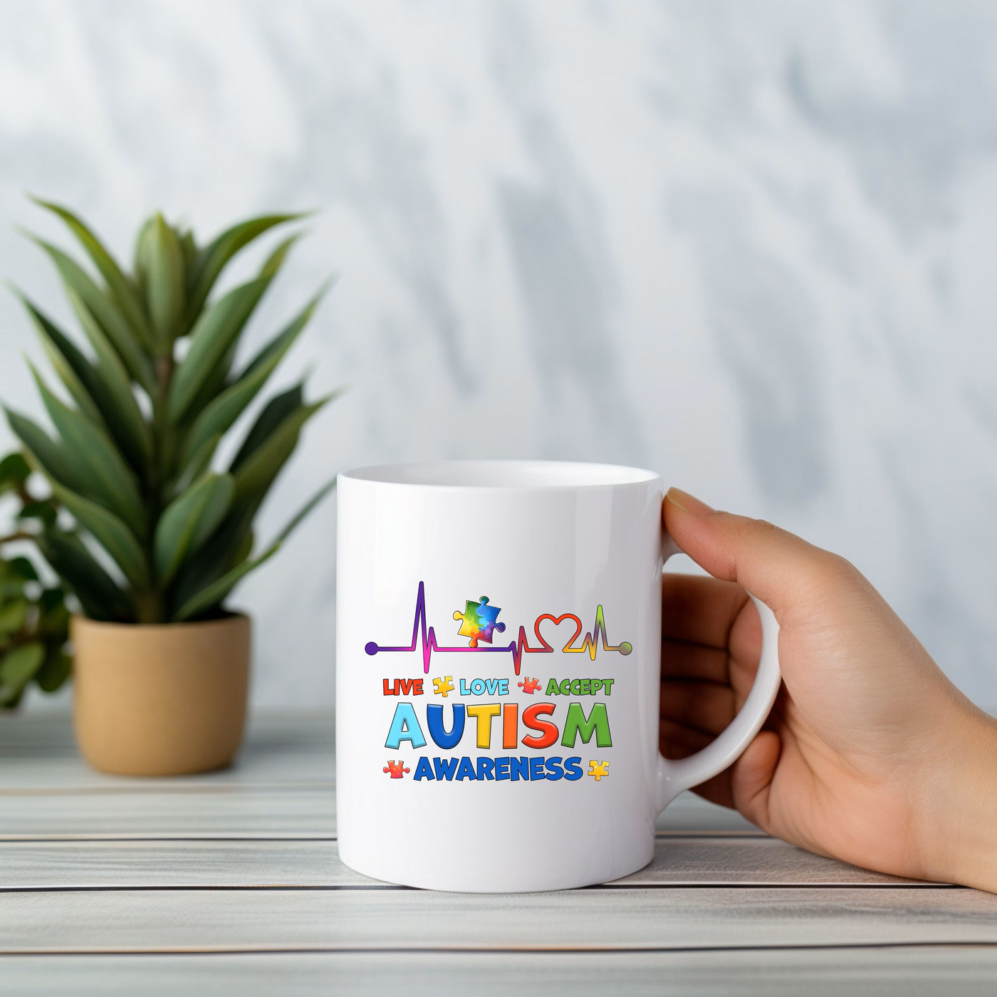 a person holding a coffee mug with autism on it