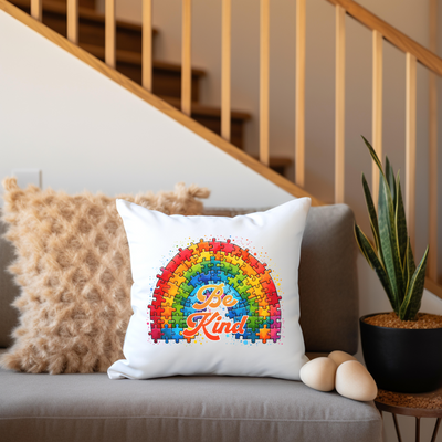 a rainbow pillow sitting on a couch next to a potted plant