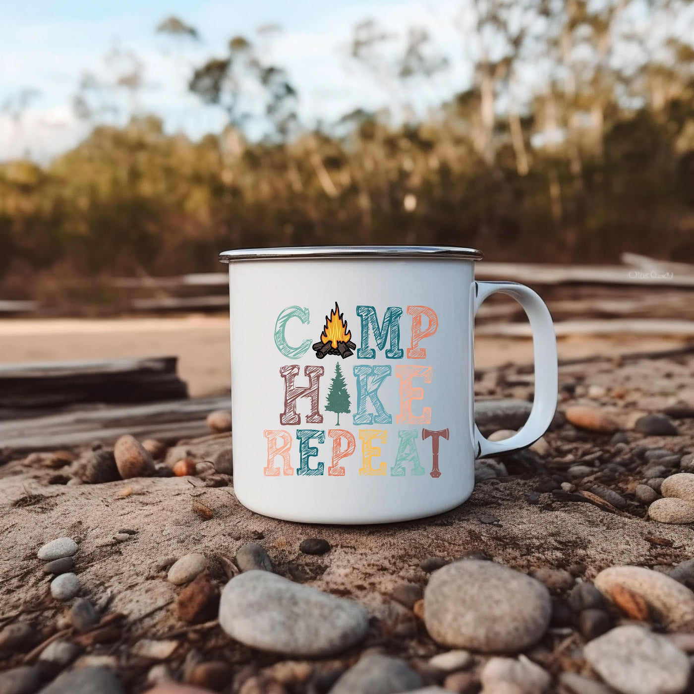 a camp hike mug sitting on a rocky beach