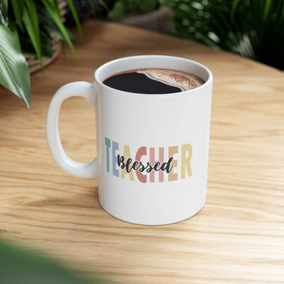 a white coffee mug with the word teacher on it