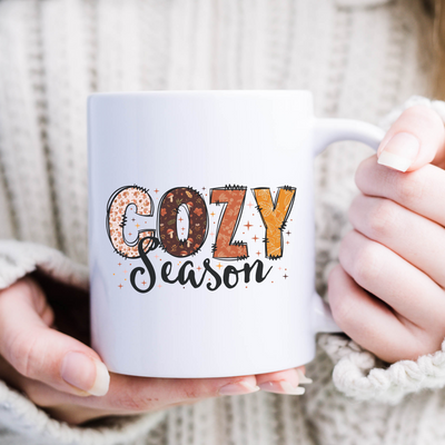 a woman holding a coffee mug with the words gozy season printed on it