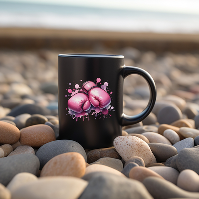 a black coffee mug with pink boxing gloves on it