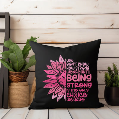 a black pillow with a pink sunflower on it