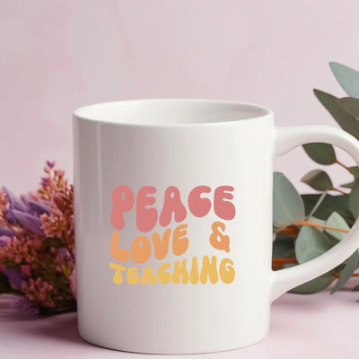 a white coffee mug with the words peace love and teaching on it