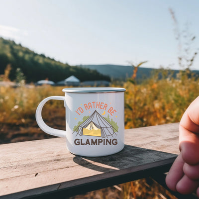 a person holding a coffee mug with a tent in the background