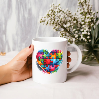 a person holding a coffee mug with a puzzle heart on it