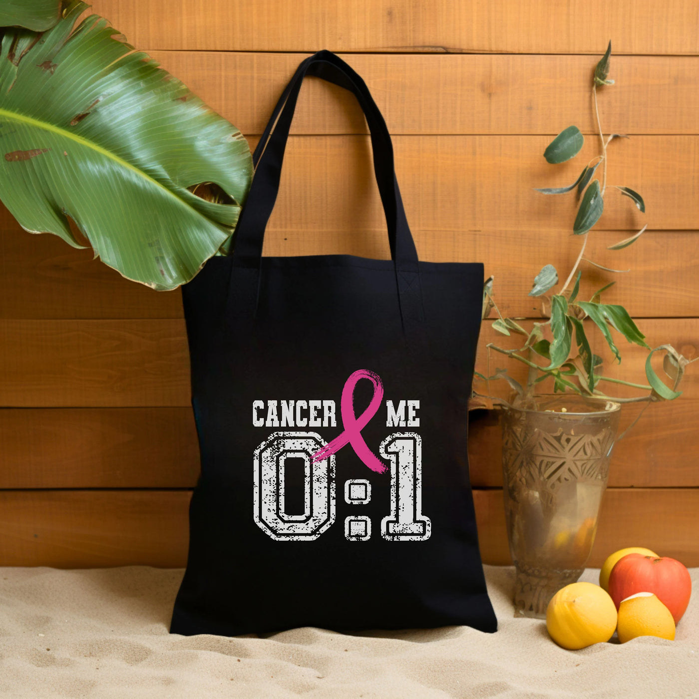 a black tote bag with a pink ribbon on it