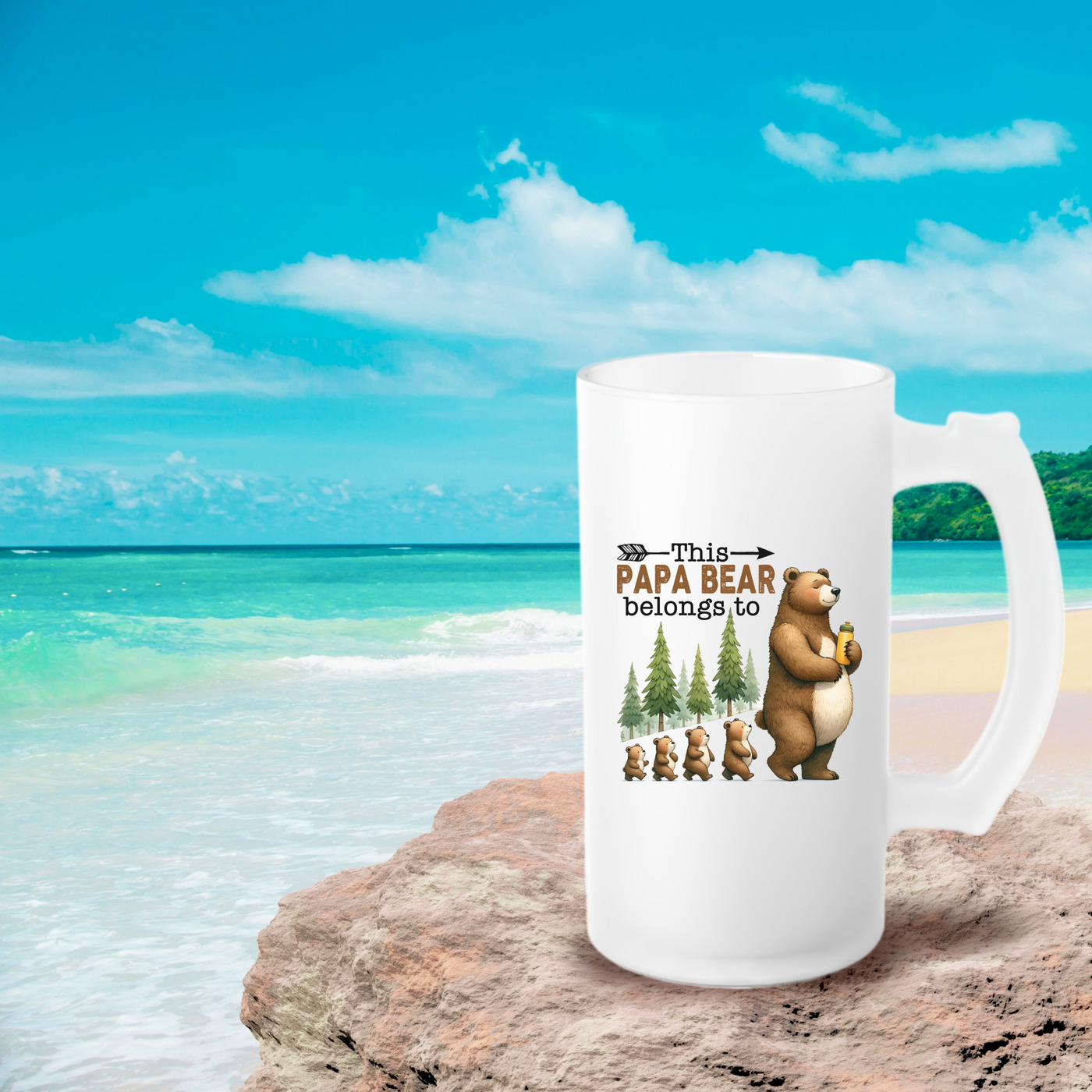 a white coffee mug sitting on top of a sandy beach