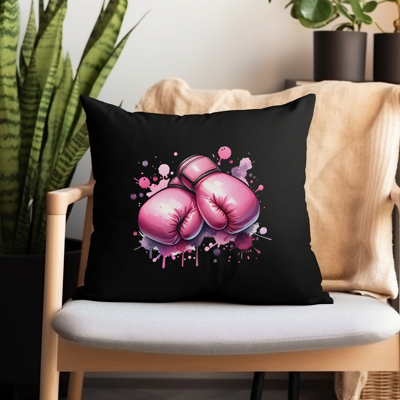 a black pillow with pink boxing gloves on it