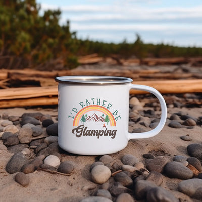 a white coffee cup sitting on top of a sandy beach