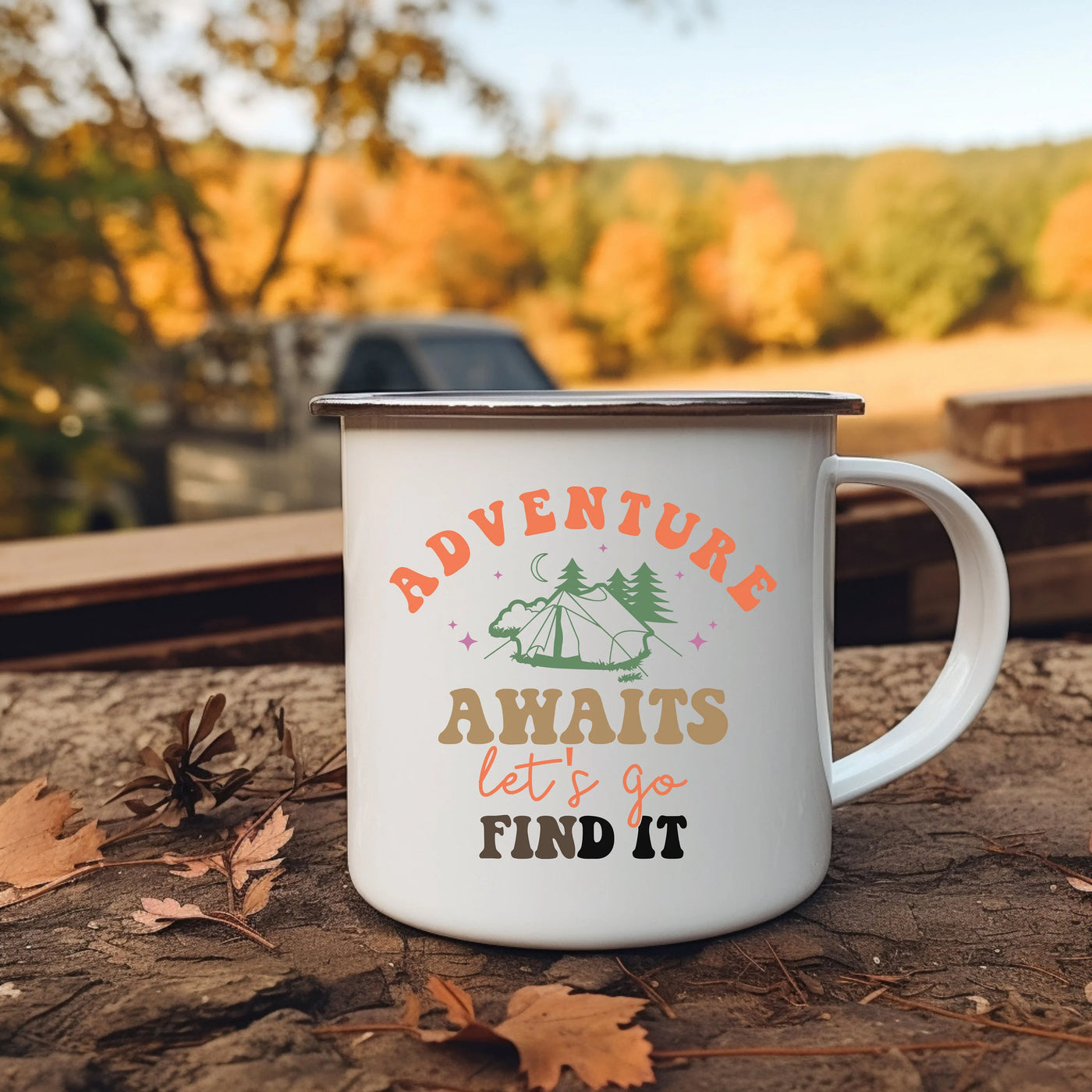 a camper mug sitting on the ground with leaves around it