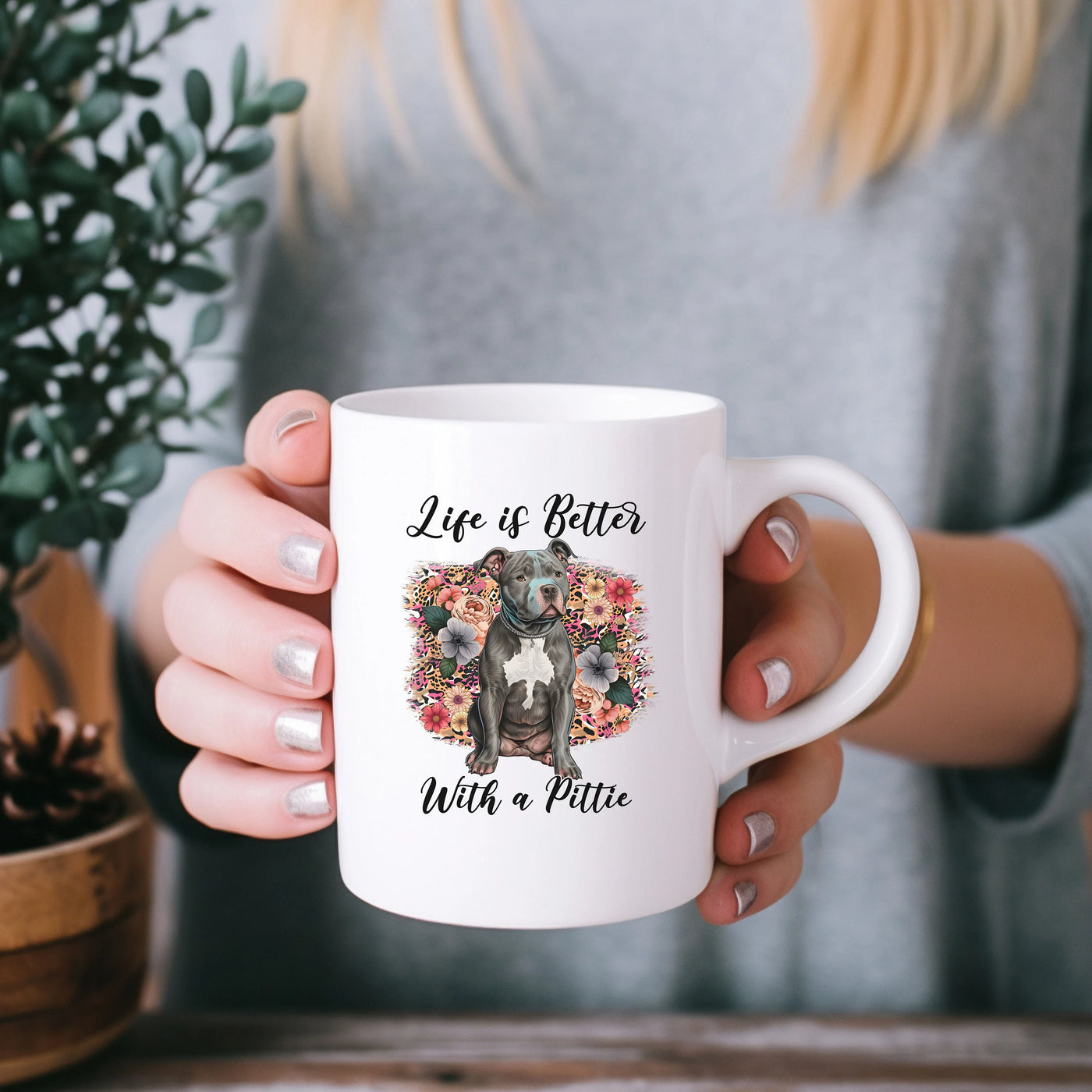 a woman holding a coffee mug with a dog on it