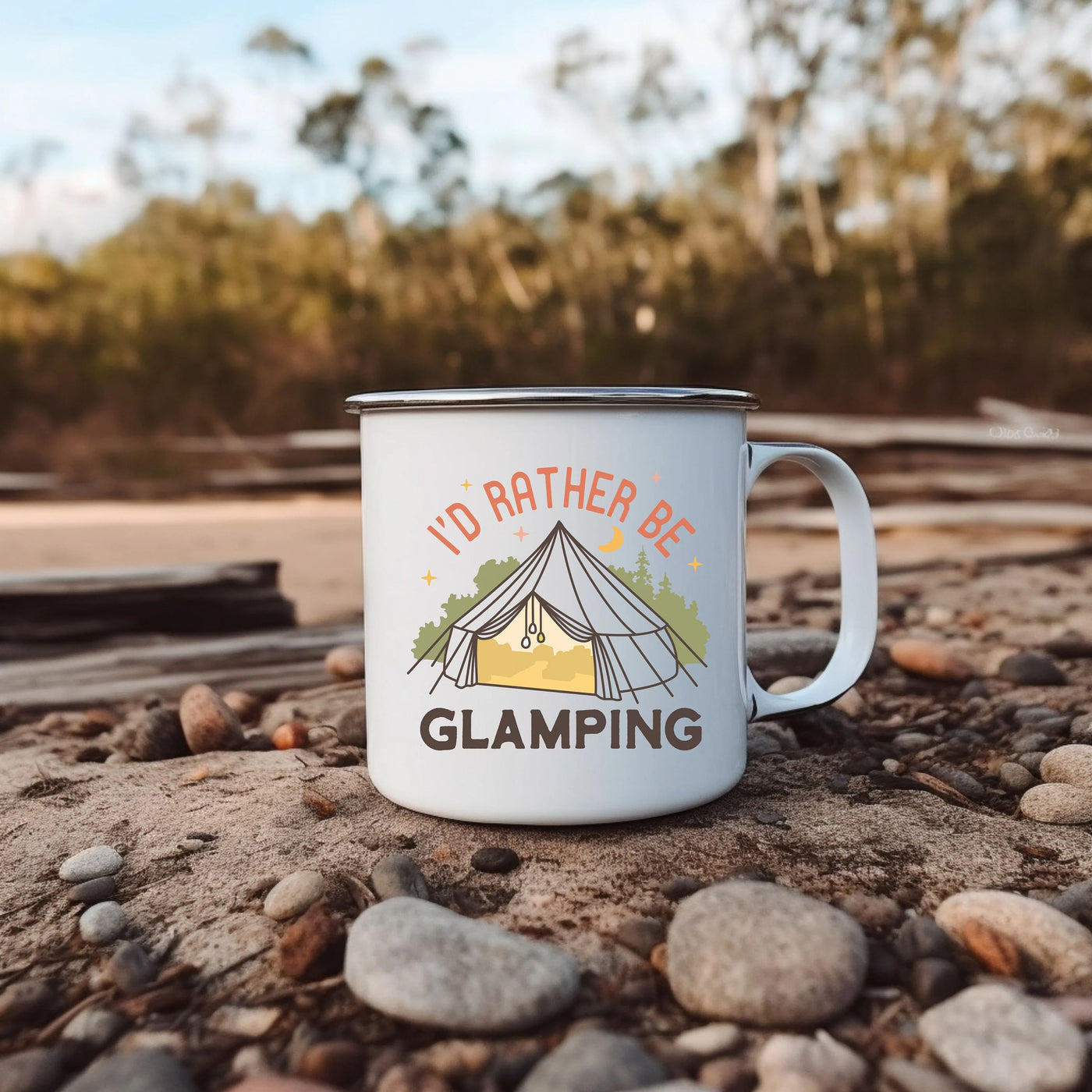 a camp mug sitting on the ground with a tent in the background