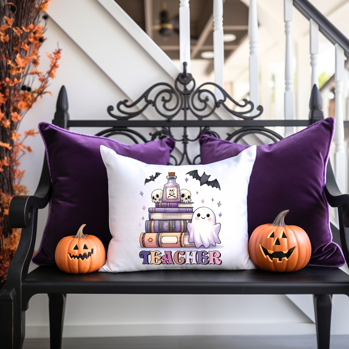 a black bench with two pumpkins and a pillow on it