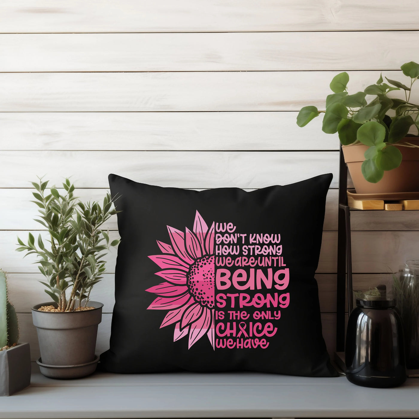 a black pillow with a pink sunflower on it