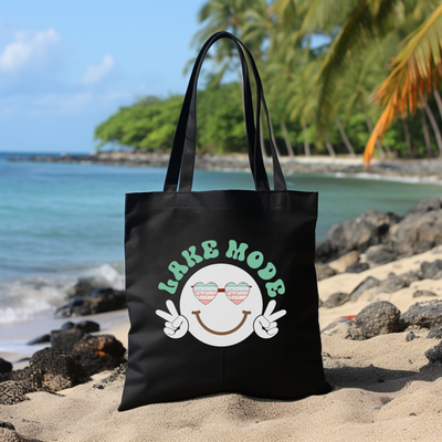 a black tote bag sitting on top of a sandy beach